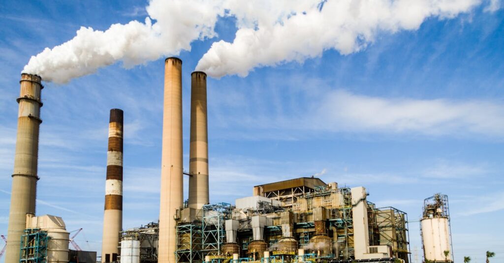 A large industrial power plant with smokestacks emitting smoke under a blue sky, symbolizing pollution.